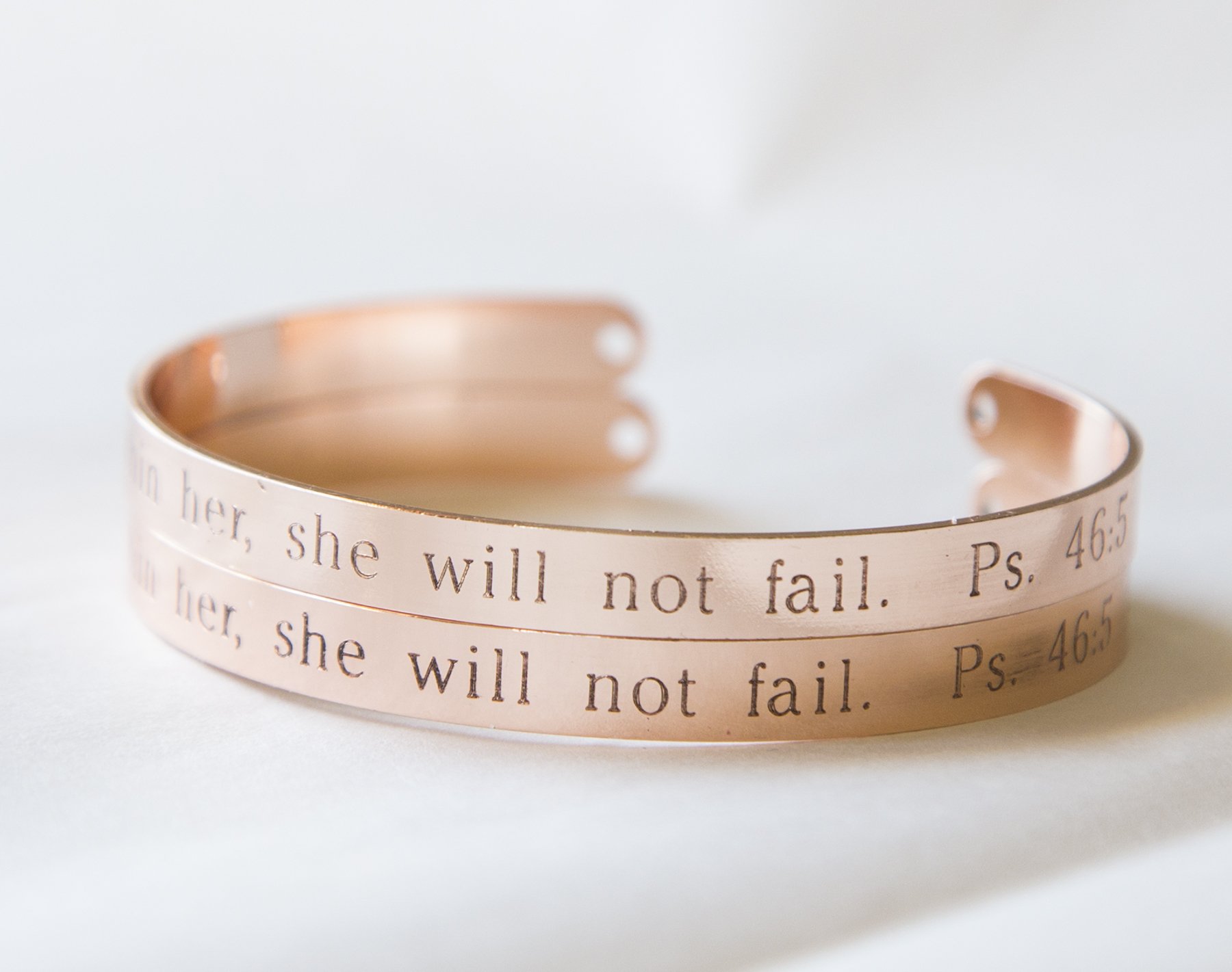 A delicate adjustable cuff bracelet engraved with 'God is Within Her She Will Not Fail', showcasing its inspirational message and elegant design.