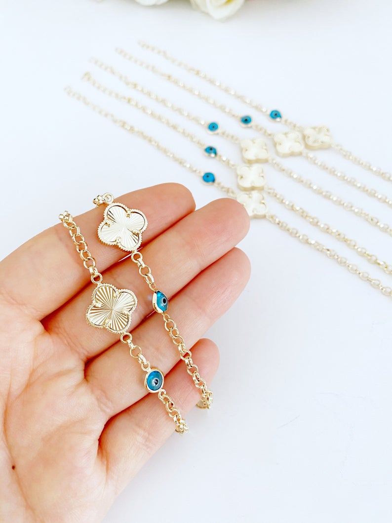 Gold Clover Bracelet featuring a blue evil eye bead and lucky clover charm, handmade with intricate details.