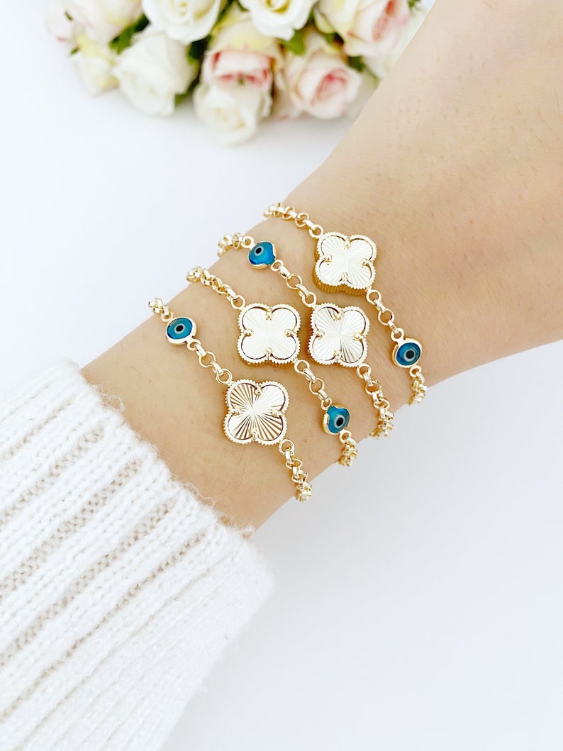 Gold Clover Bracelet featuring a blue evil eye bead and lucky clover charm, handmade with intricate details.