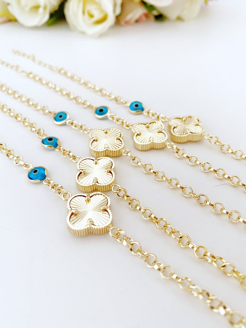Gold Clover Bracelet featuring a blue evil eye bead and lucky clover charm, handmade with intricate details.