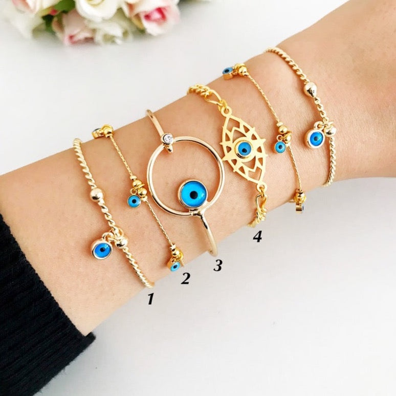 A beautiful Gold Evil Eye Bracelet made of tarnish-resistant stainless steel, featuring an adjustable design and available in four unique styles.