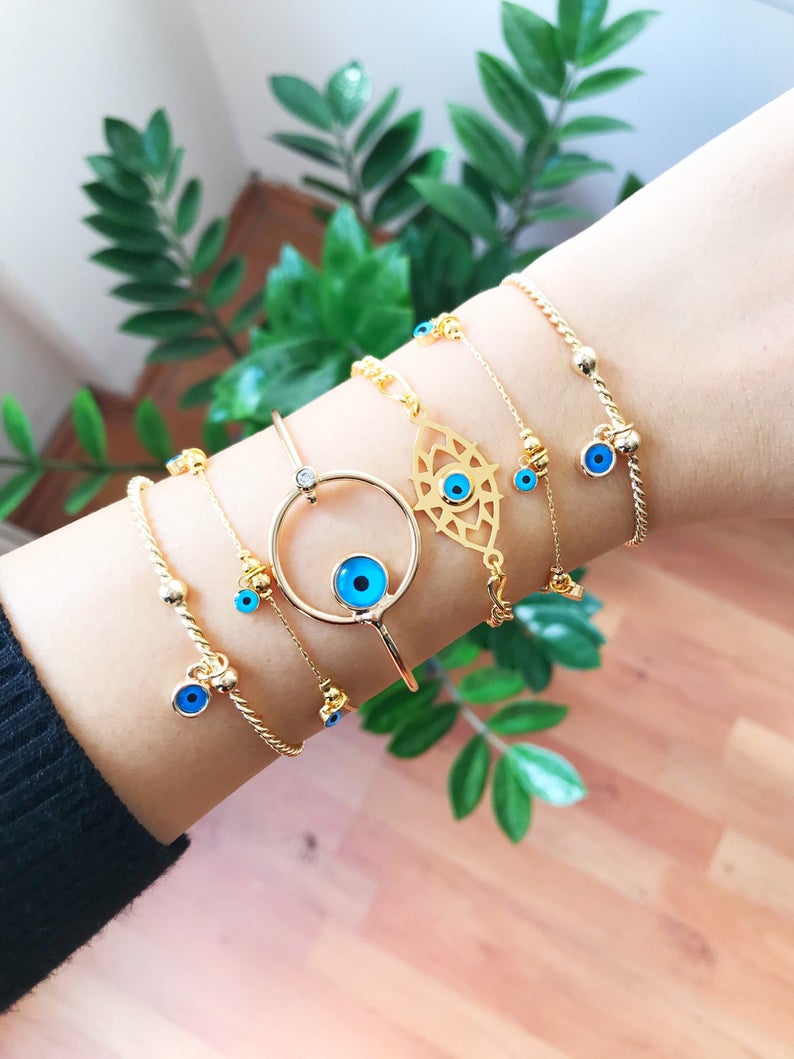 A beautiful Gold Evil Eye Bracelet made of tarnish-resistant stainless steel, featuring an adjustable design and available in four unique styles.