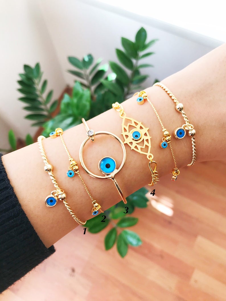 A beautiful Gold Evil Eye Bracelet made of tarnish-resistant stainless steel, featuring an adjustable design and available in four unique styles.
