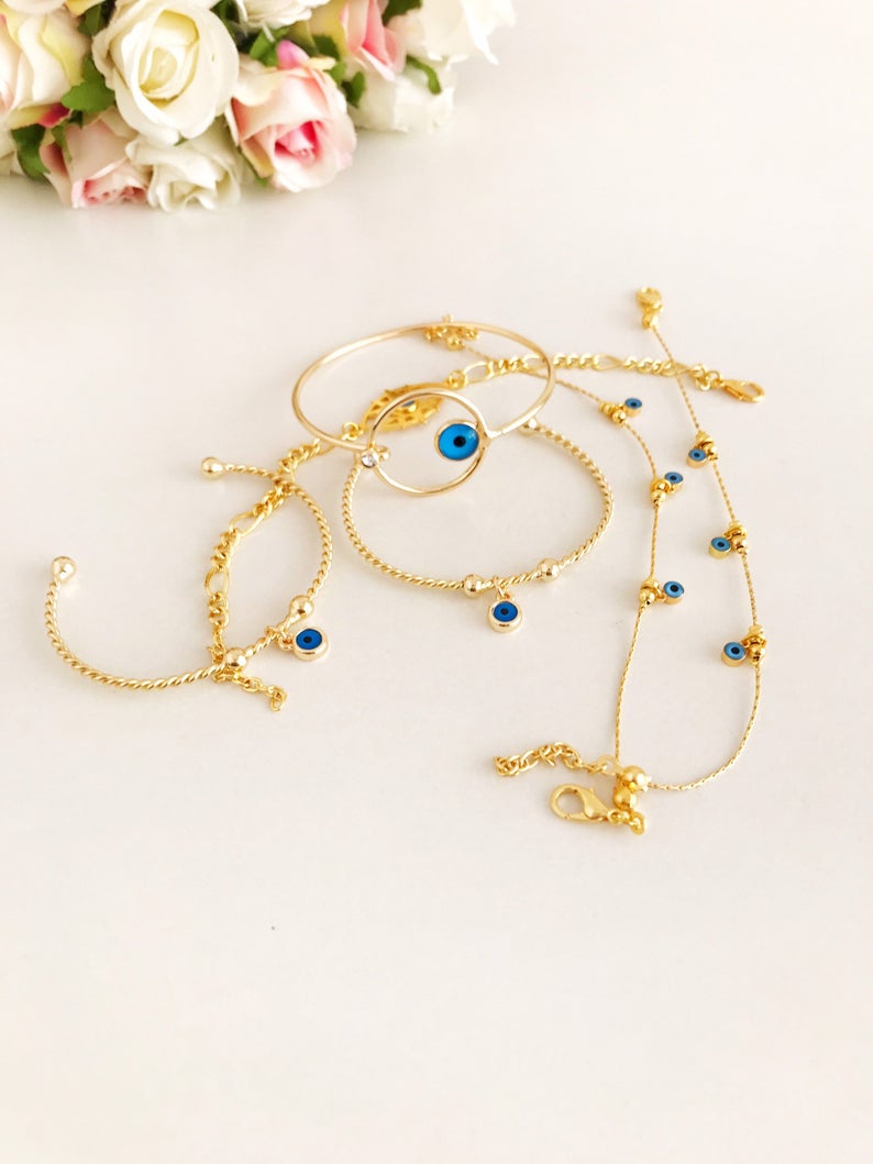 A beautiful Gold Evil Eye Bracelet made of tarnish-resistant stainless steel, featuring an adjustable design and available in four unique styles.