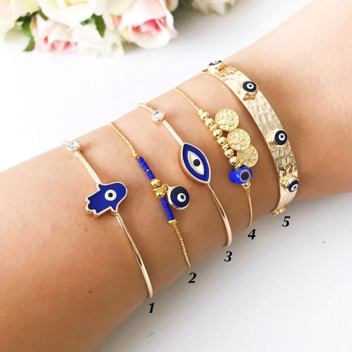 A beautiful Gold Evil Eye Bracelet featuring a blue evil eye bead, showcasing its handmade craftsmanship and adjustable design.