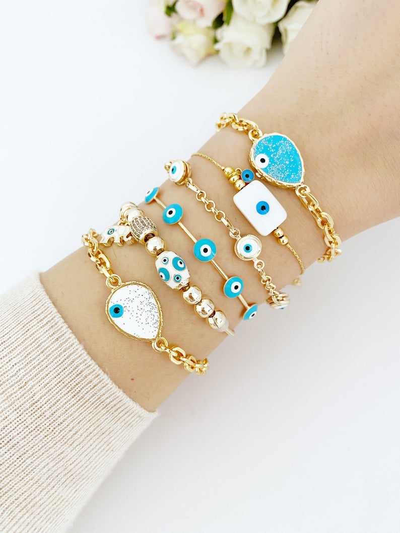Gold Evil Eye Bracelet featuring a blue evil eye design, adjustable cuff style, handmade with tarnish-resistant stainless steel.
