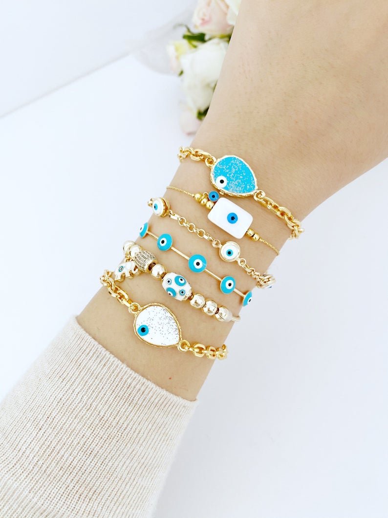 Gold Evil Eye Bracelet featuring a blue evil eye design, adjustable cuff style, handmade with tarnish-resistant stainless steel.