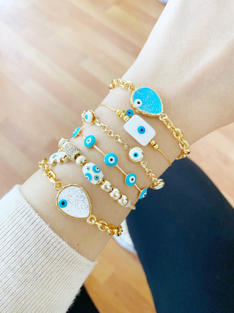 Gold Evil Eye Bracelet featuring a blue evil eye design, adjustable cuff style, handmade with tarnish-resistant stainless steel.