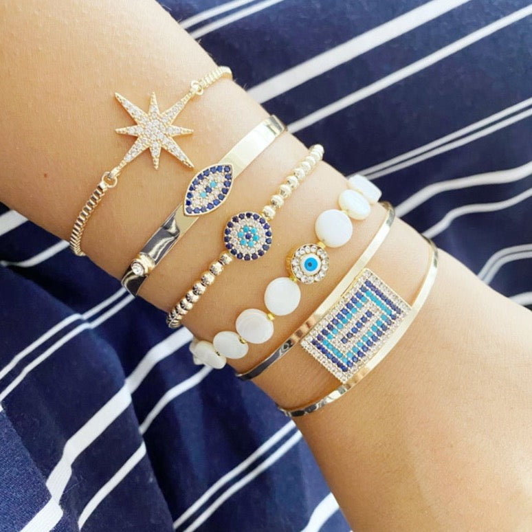 Gold Evil Eye Bracelet featuring a movable oval charm and adjustable cuff design, handmade with tarnish-resistant stainless steel.