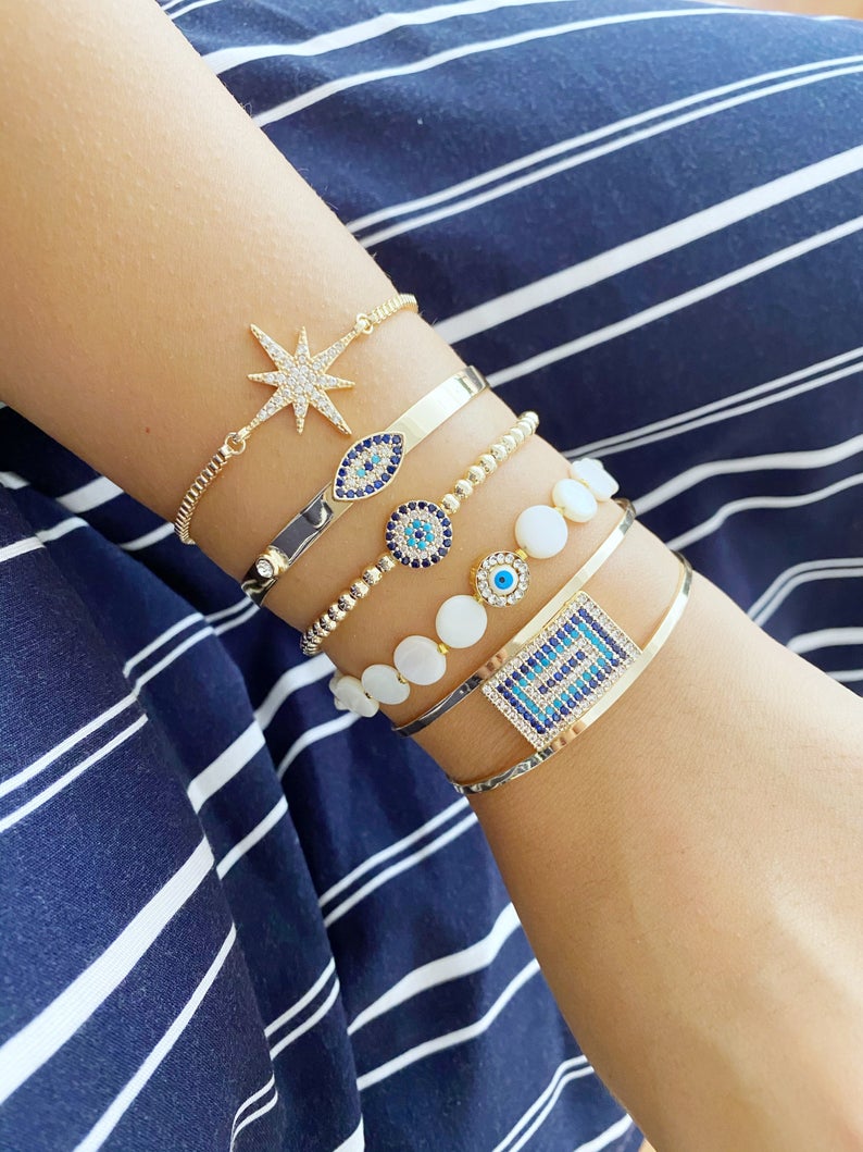 Gold Evil Eye Bracelet featuring a movable oval charm and adjustable cuff design, handmade with tarnish-resistant stainless steel.