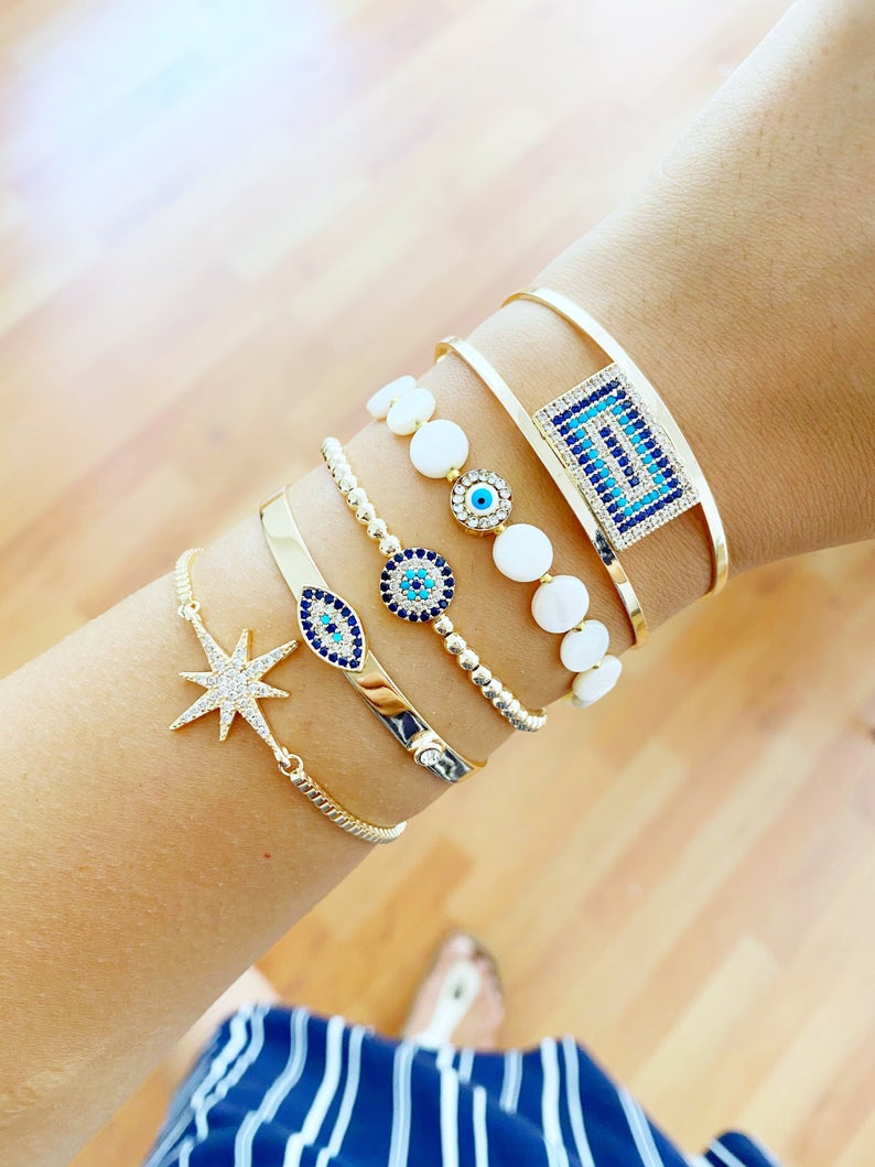 Gold Evil Eye Bracelet featuring a movable oval charm and adjustable cuff design, handmade with tarnish-resistant stainless steel.