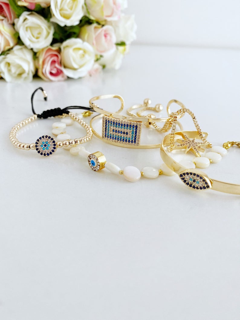 Gold Evil Eye Bracelet featuring a movable oval charm and adjustable cuff design, handmade with tarnish-resistant stainless steel.