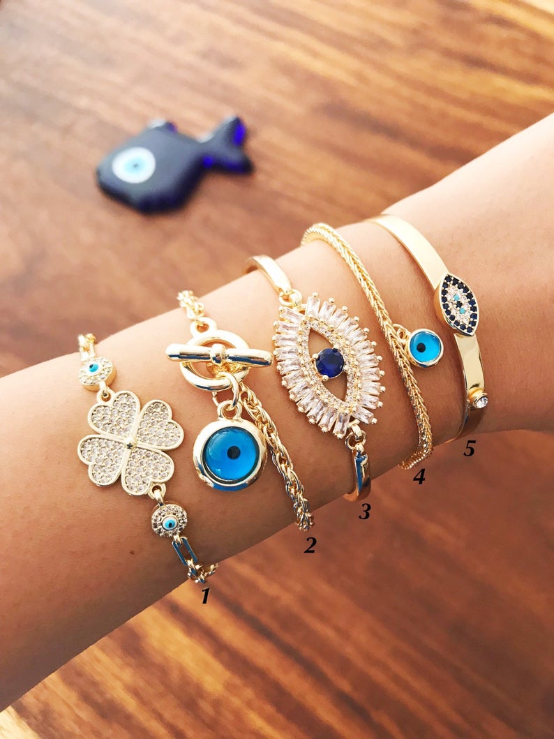 Gold Evil Eye Bracelet Set featuring adjustable bangles with blue evil eye beads, showcasing handmade craftsmanship and tarnish-resistant stainless steel.