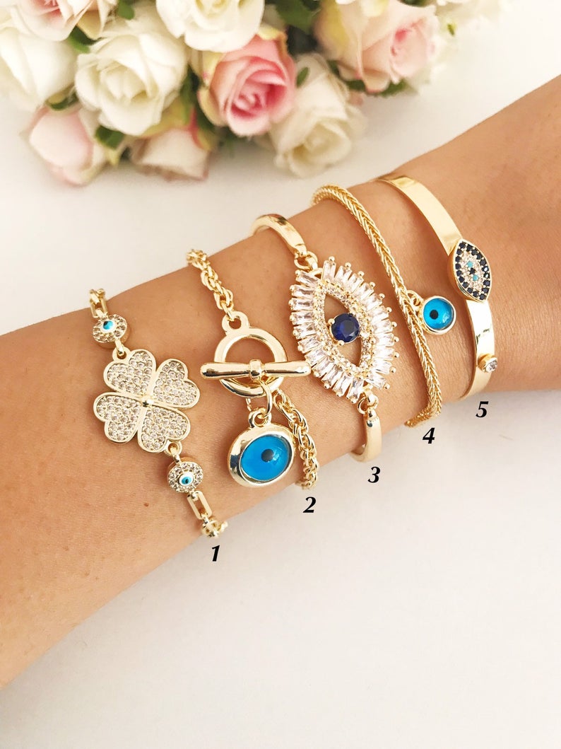 Gold Evil Eye Bracelet Set featuring adjustable bangles with blue evil eye beads, showcasing handmade craftsmanship and tarnish-resistant stainless steel.