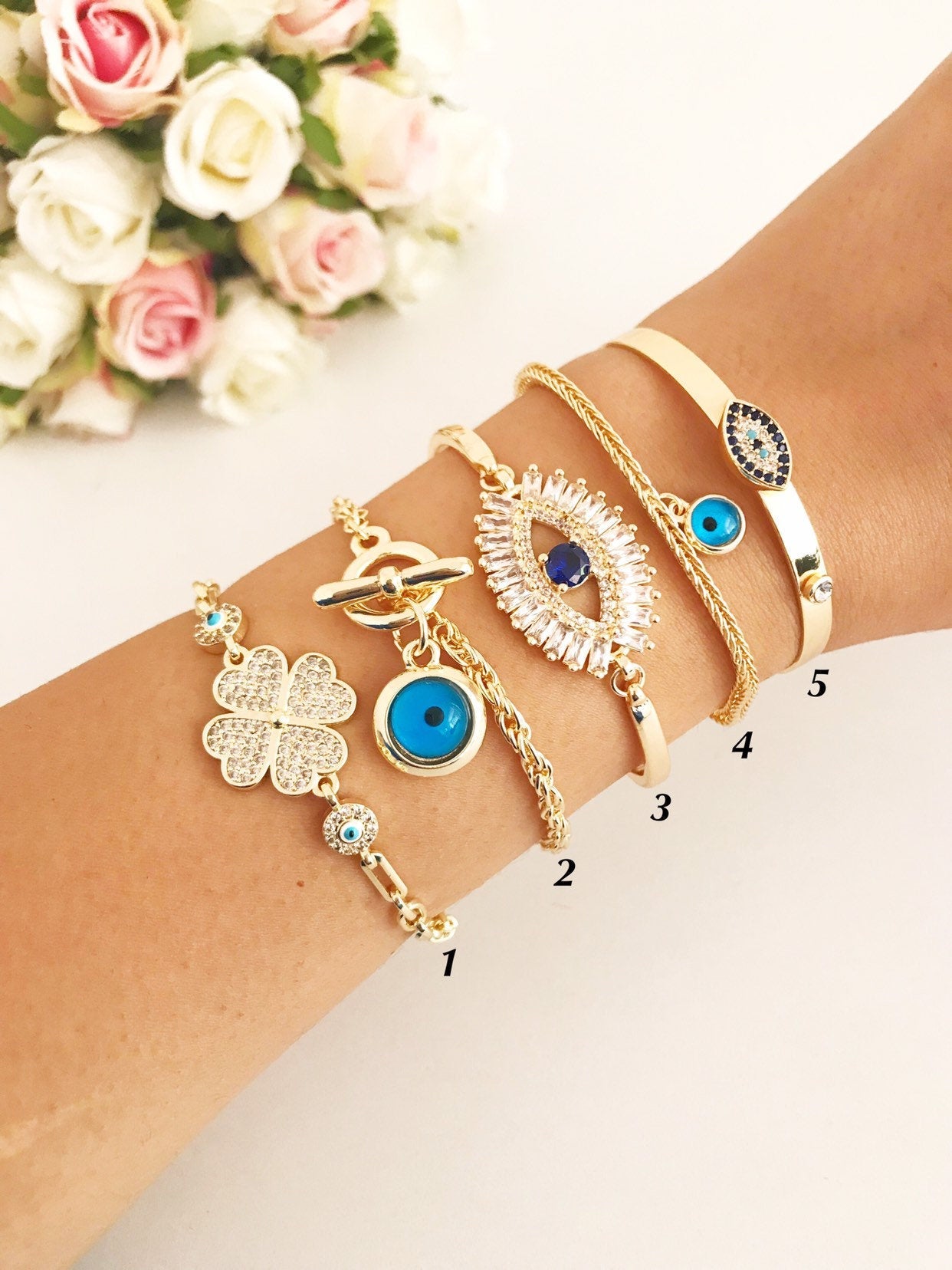Gold Evil Eye Bracelet Set featuring adjustable bangles with blue evil eye beads, showcasing handmade craftsmanship and tarnish-resistant stainless steel.