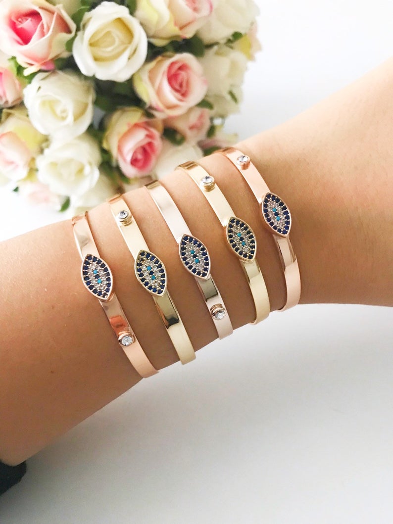 Gold Evil Eye Bracelet Set featuring adjustable bangles with blue evil eye beads, showcasing handmade craftsmanship and tarnish-resistant stainless steel.