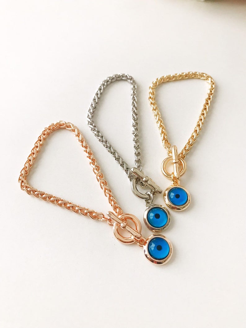 Gold Evil Eye Bracelet Set featuring adjustable bangles with blue evil eye beads, showcasing handmade craftsmanship and tarnish-resistant stainless steel.