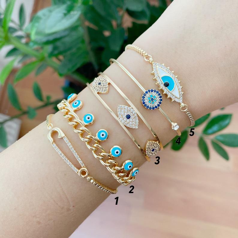 Gold Evil Eye Bracelet Set featuring five unique styles including safety pin and zircon bangle, adorned with blue evil eye beads.