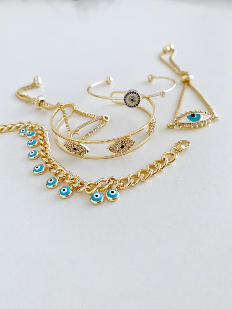 Gold Evil Eye Bracelet Set featuring five unique styles including safety pin and zircon bangle, adorned with blue evil eye beads.