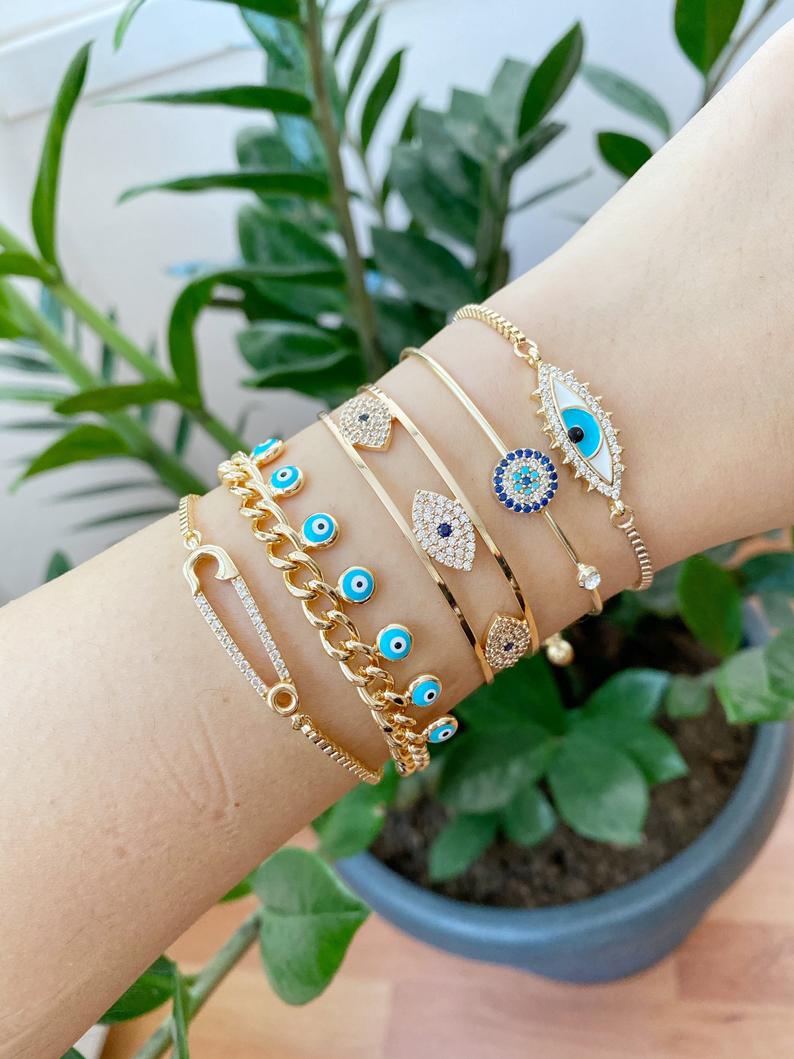 Gold Evil Eye Bracelet Set featuring five unique styles including safety pin and zircon bangle, adorned with blue evil eye beads.