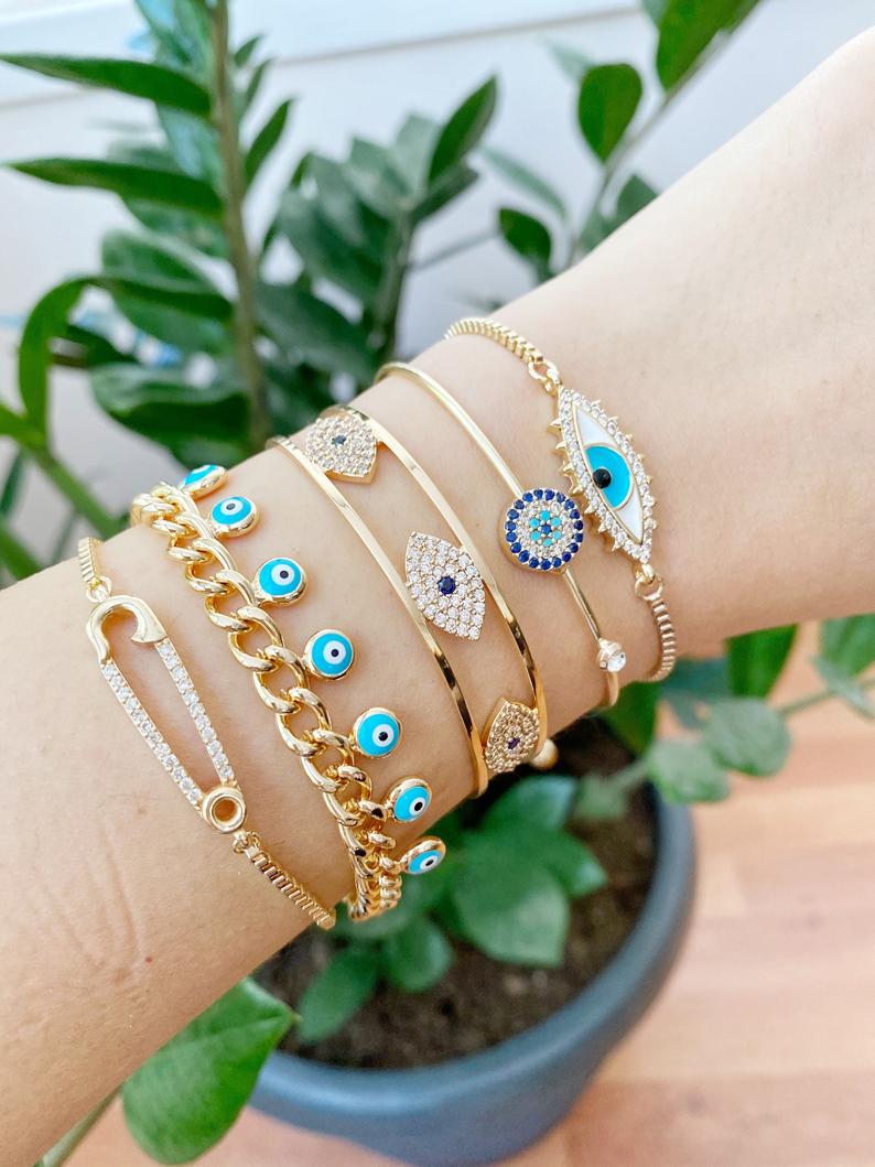 Gold Evil Eye Bracelet Set featuring five unique styles including safety pin and zircon bangle, adorned with blue evil eye beads.