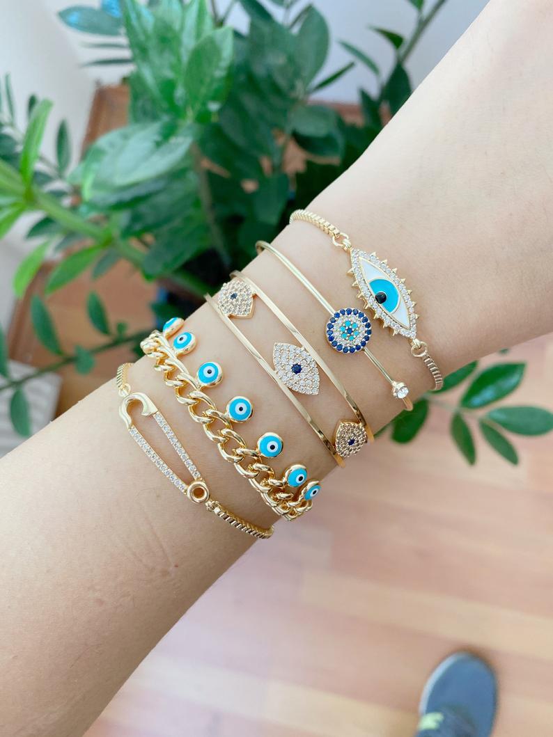 Gold Evil Eye Bracelet Set featuring five unique styles including safety pin and zircon bangle, adorned with blue evil eye beads.
