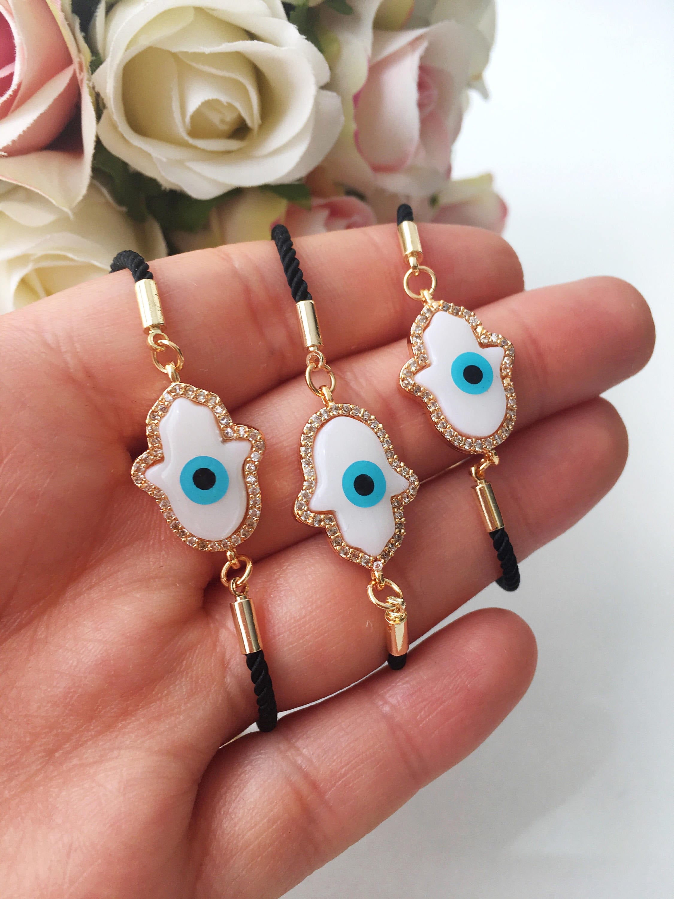 A beautiful set of handmade gold evil eye bracelets featuring bangle and beaded designs, including hamsa charm for protection.