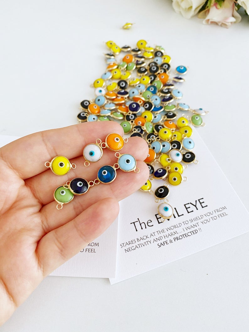 A collection of 25 gold and silver glass evil eye charms, each 10mm in diameter, perfect for DIY jewelry projects.