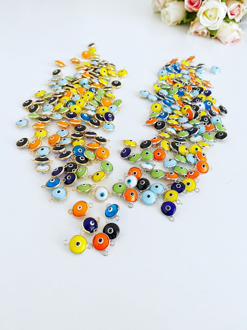 A collection of 25 gold and silver glass evil eye charms, each 10mm in diameter, perfect for DIY jewelry projects.