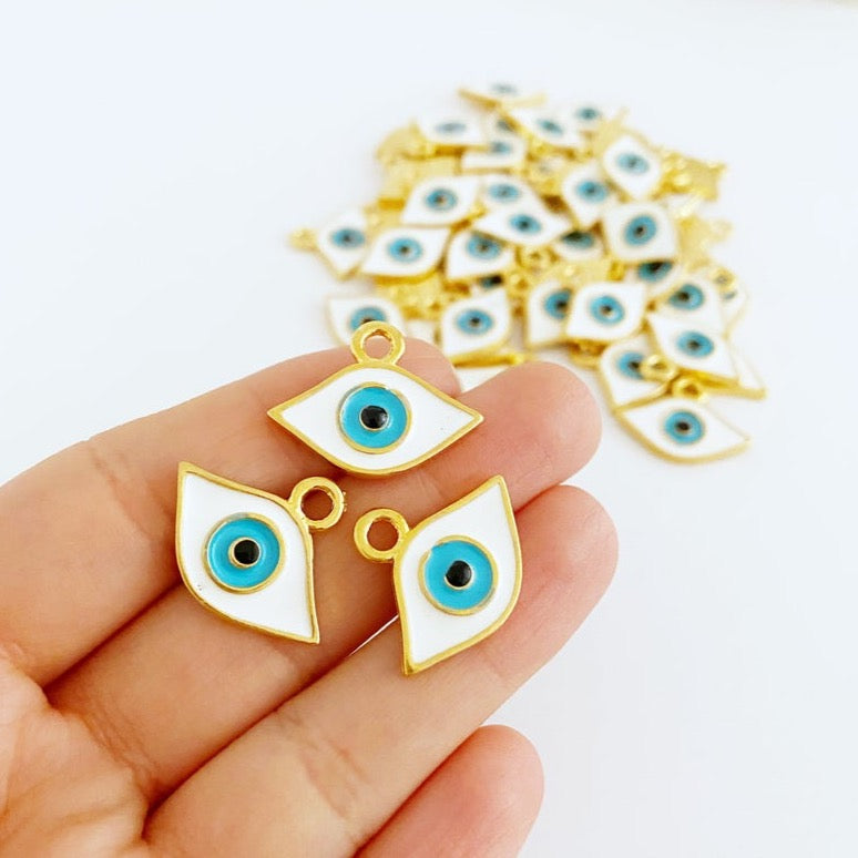 A detailed view of a gold evil eye charm, featuring a tiny oval shape with a white eye design, perfect for jewelry making.