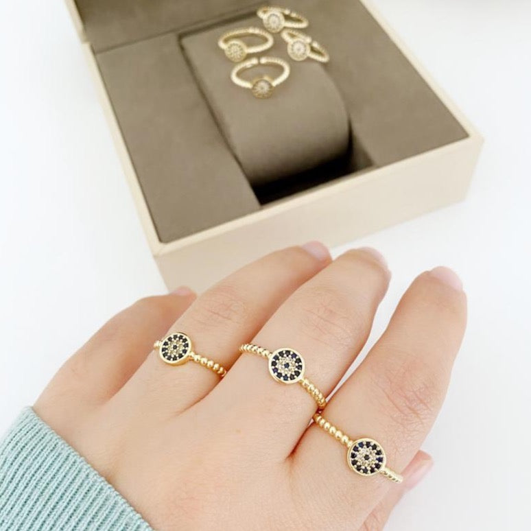 A delicate gold evil eye ring featuring a zircon charm, adjustable for all sizes, perfect for everyday wear.