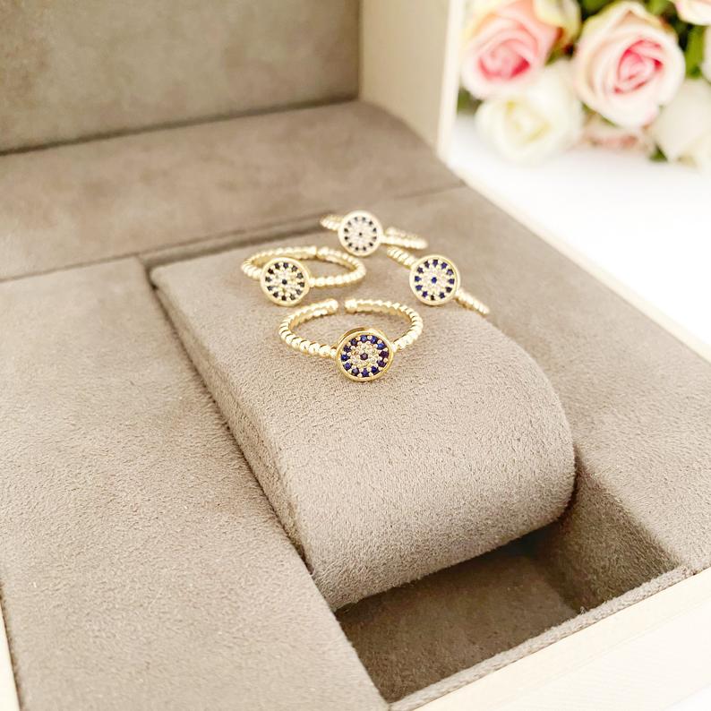 A delicate gold evil eye ring featuring a zircon charm, adjustable for all sizes, perfect for everyday wear.