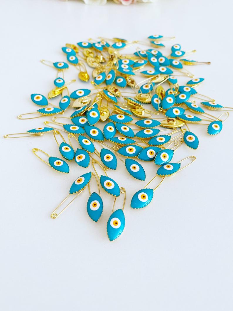 Gold Evil Eye Safety Pin featuring a blue evil eye charm, perfect for weddings and baby showers.
