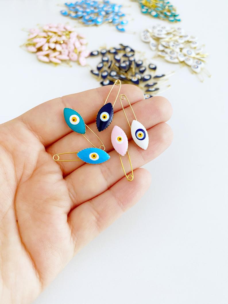 Gold Evil Eye Safety Pin featuring a blue evil eye charm, perfect for weddings and baby showers.