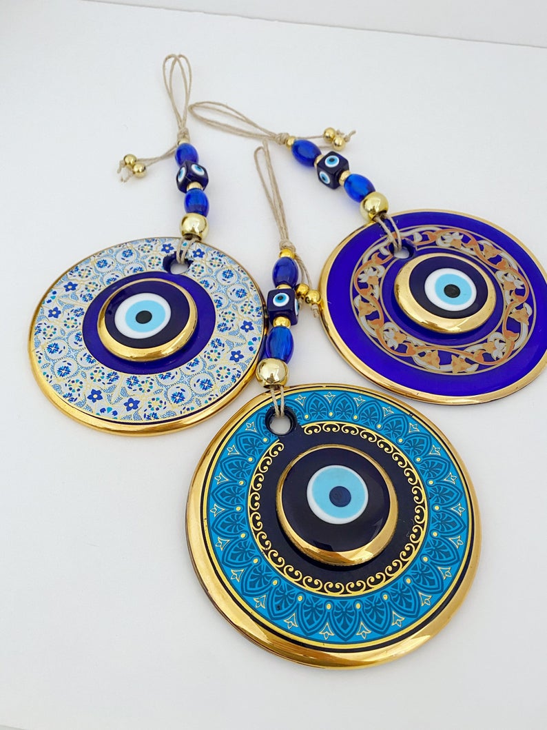 A beautiful Gold Evil Eye Wall Hanging featuring intricate designs, large and small evil eye motifs, perfect for home decor and protection.