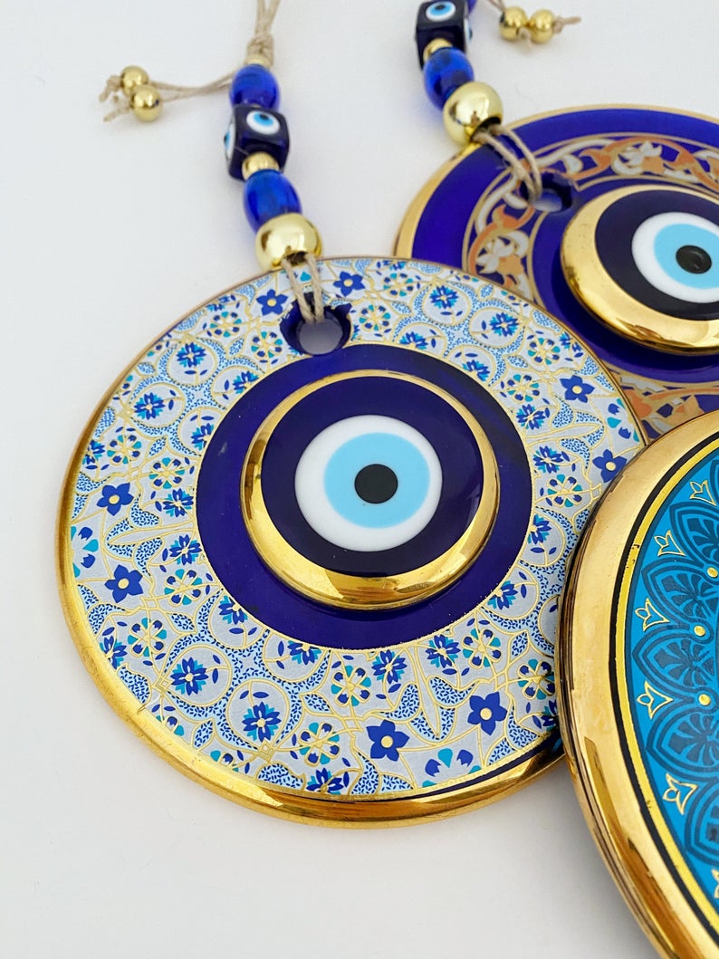 A beautiful Gold Evil Eye Wall Hanging featuring intricate designs, large and small evil eye motifs, perfect for home decor and protection.