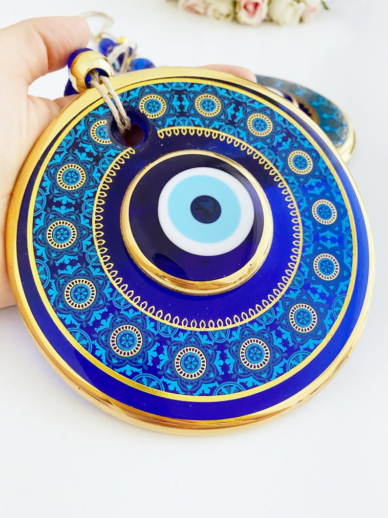 A beautiful Gold Evil Eye Wall Hanging featuring intricate designs, large and small evil eye motifs, perfect for home decor and protection.