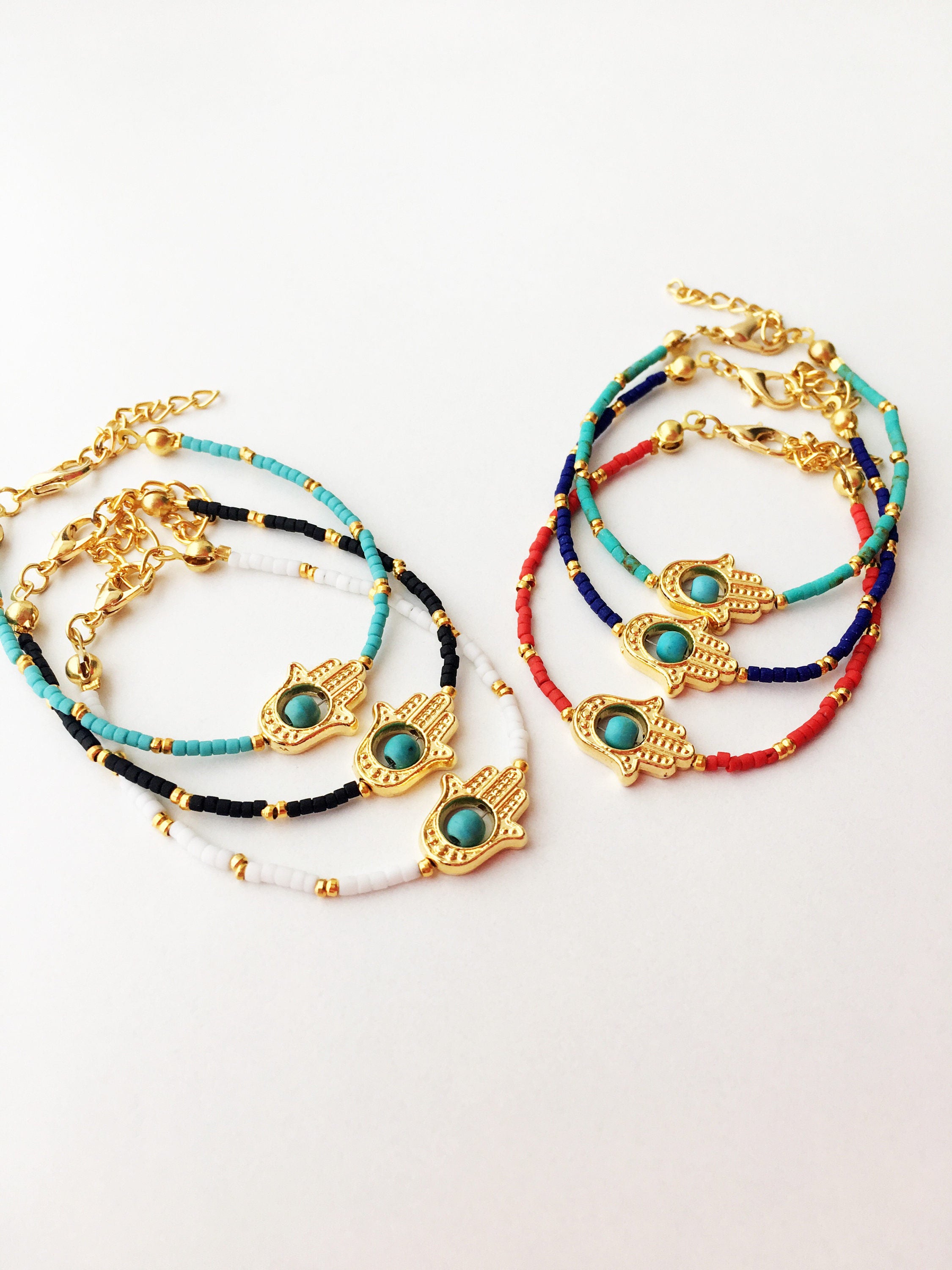 Gold Hamsa Hand Bracelet featuring colorful seed beads and a turquoise bead design, symbolizing luck and protection.