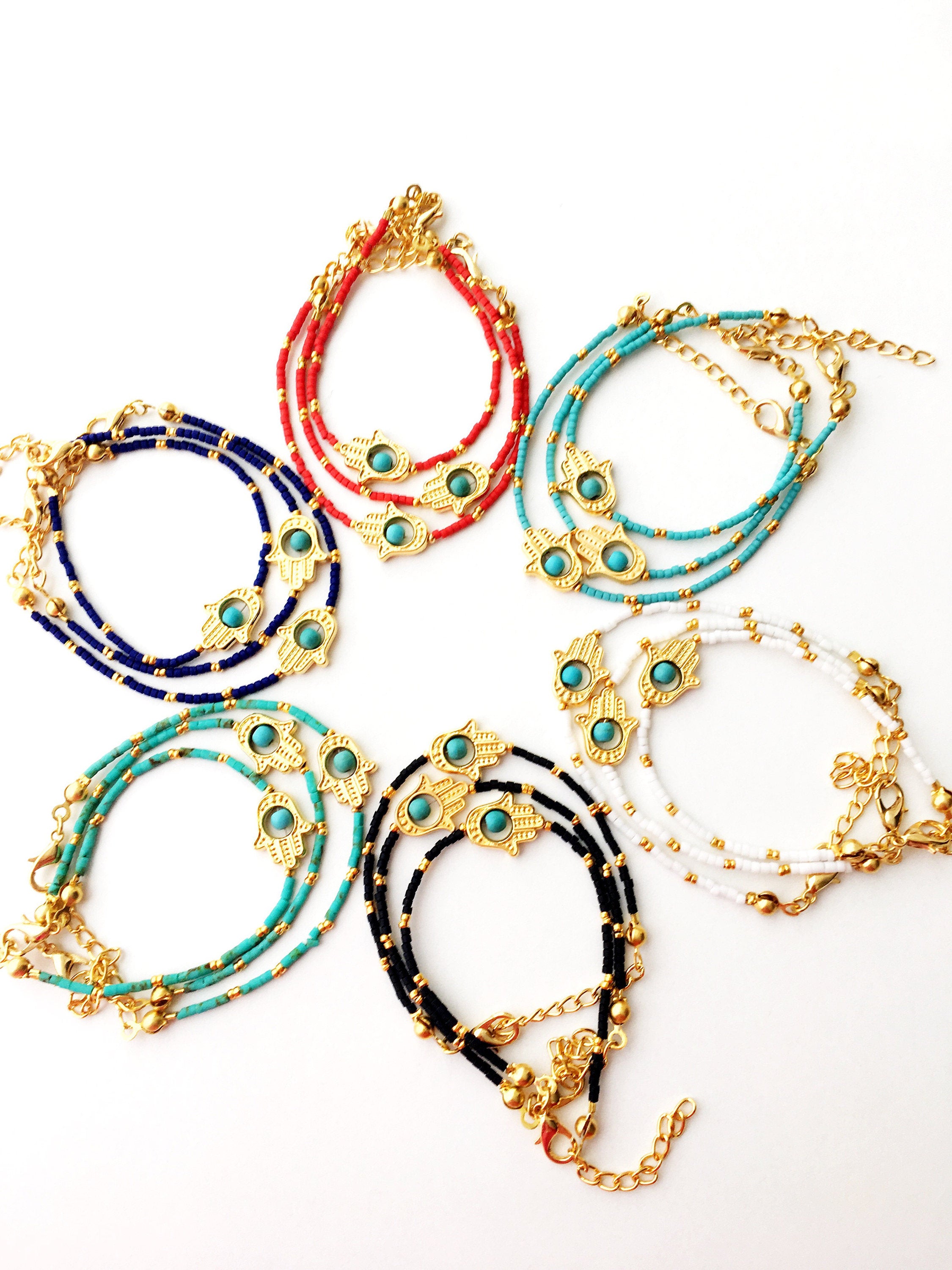 Gold Hamsa Hand Bracelet featuring colorful seed beads and a turquoise bead design, symbolizing luck and protection.