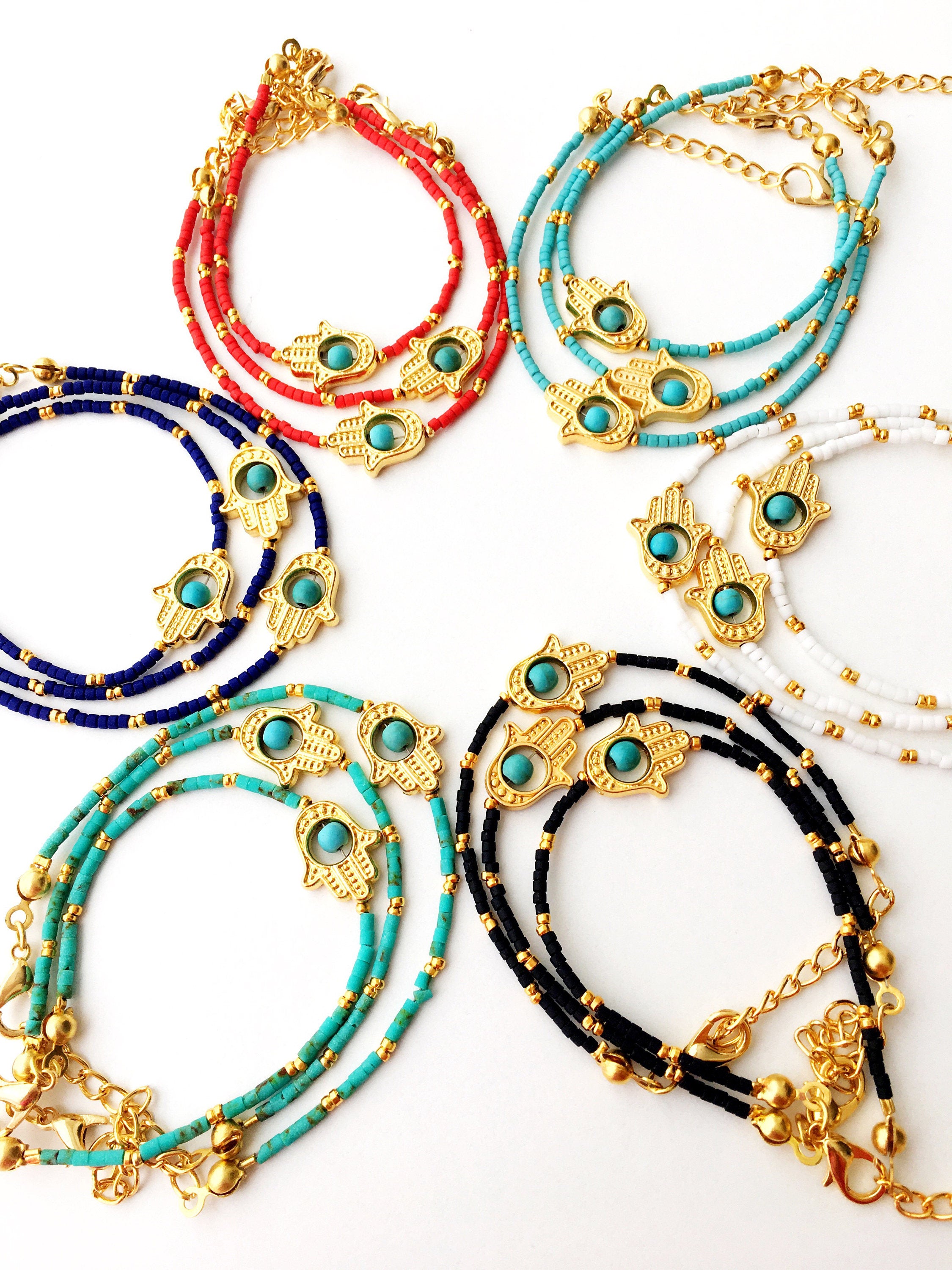 Gold Hamsa Hand Bracelet featuring colorful seed beads and a turquoise bead design, symbolizing luck and protection.