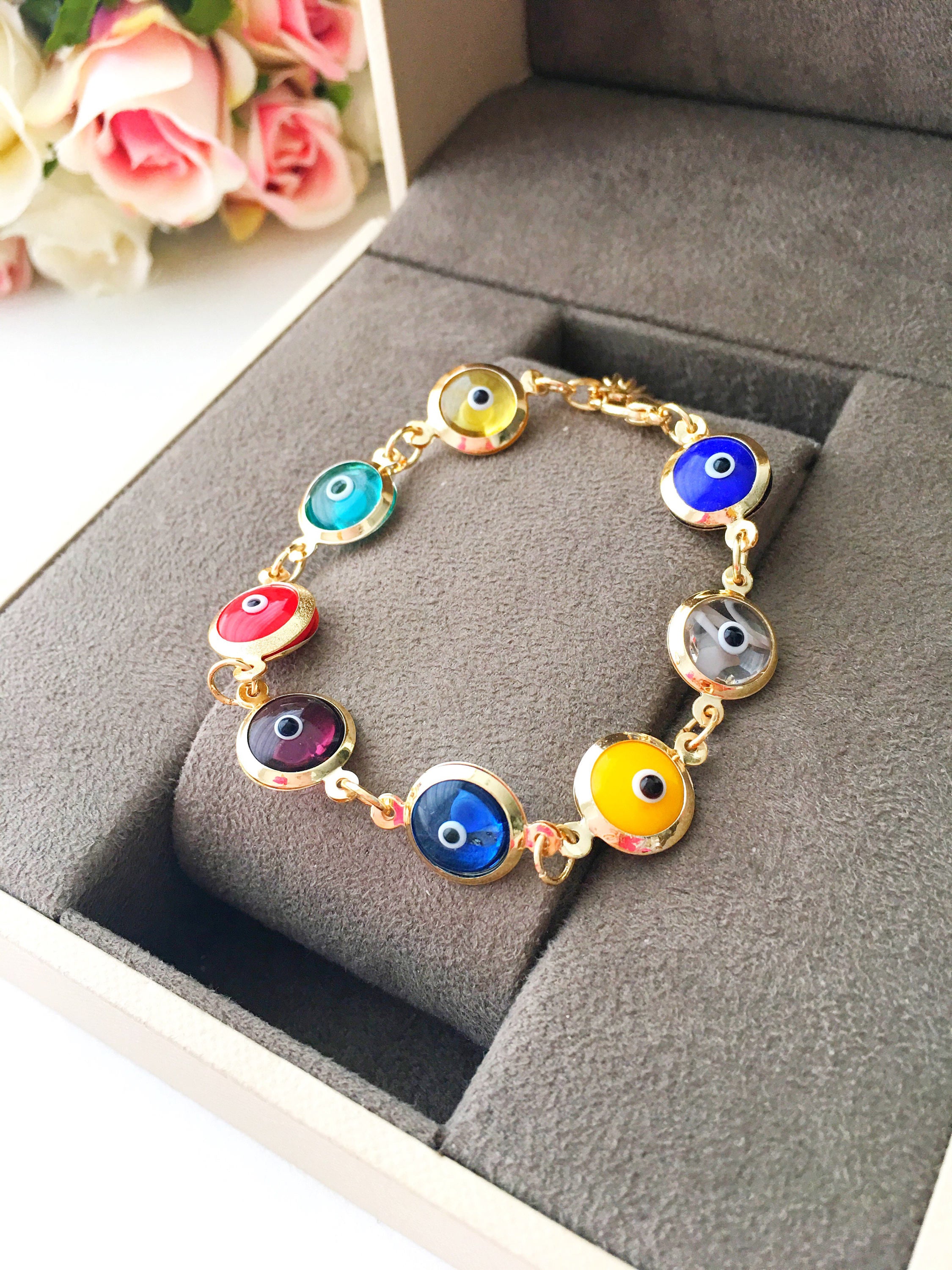 A colorful Gold Link Chain Bracelet featuring rainbow evil eye beads and a stainless steel chain, showcasing vibrant 12mm glass beads.