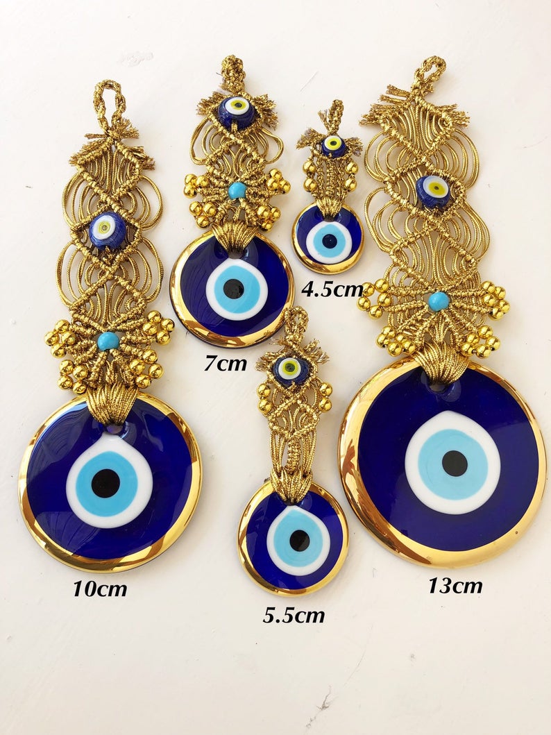 Gold macrame evil eye wall hanging featuring intricate designs and vibrant evil eye beads, symbolizing protection and good luck.