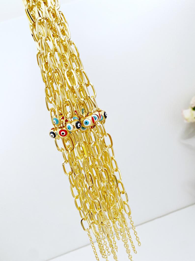 Gold Oval Link Chain Bracelet featuring an Evil Eye charm, showcasing vibrant colors and elegant design.