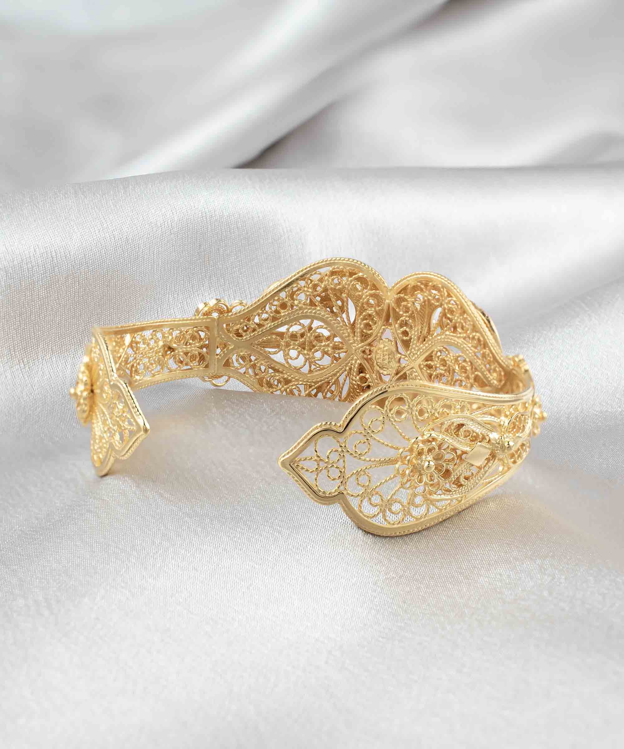 Elegant gold plated sterling silver cuff bracelet featuring intricate filigree art and a beautiful rose quartz gemstone.