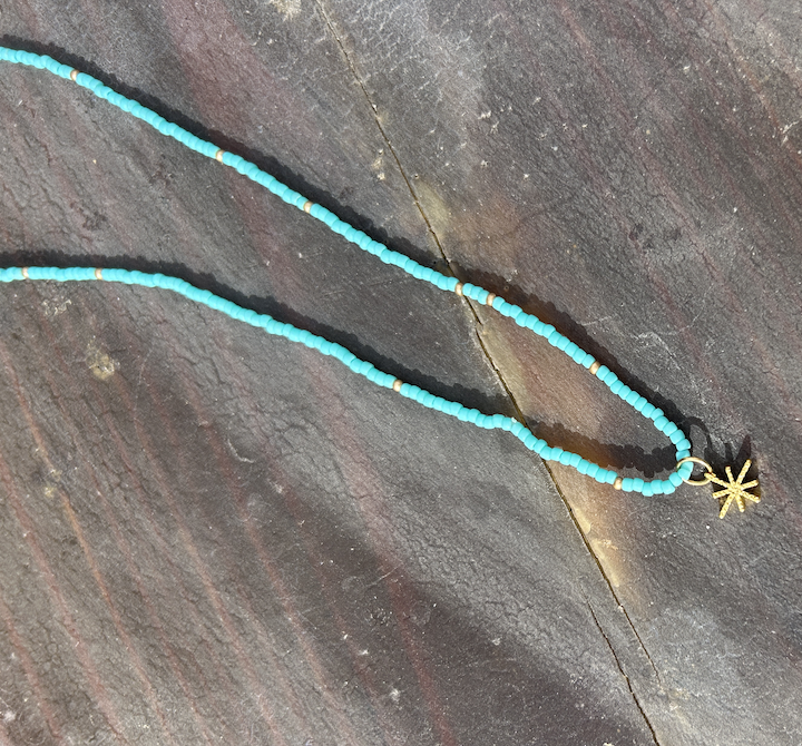 Gold Starburst Bling Turquoise Stretchy Seed Bead Necklace featuring turquoise Czech glass beads and a metallic gold starburst charm.