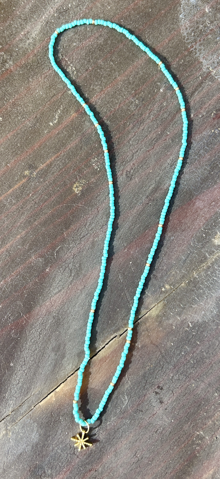 Gold Starburst Bling Turquoise Stretchy Seed Bead Necklace featuring turquoise Czech glass beads and a metallic gold starburst charm.
