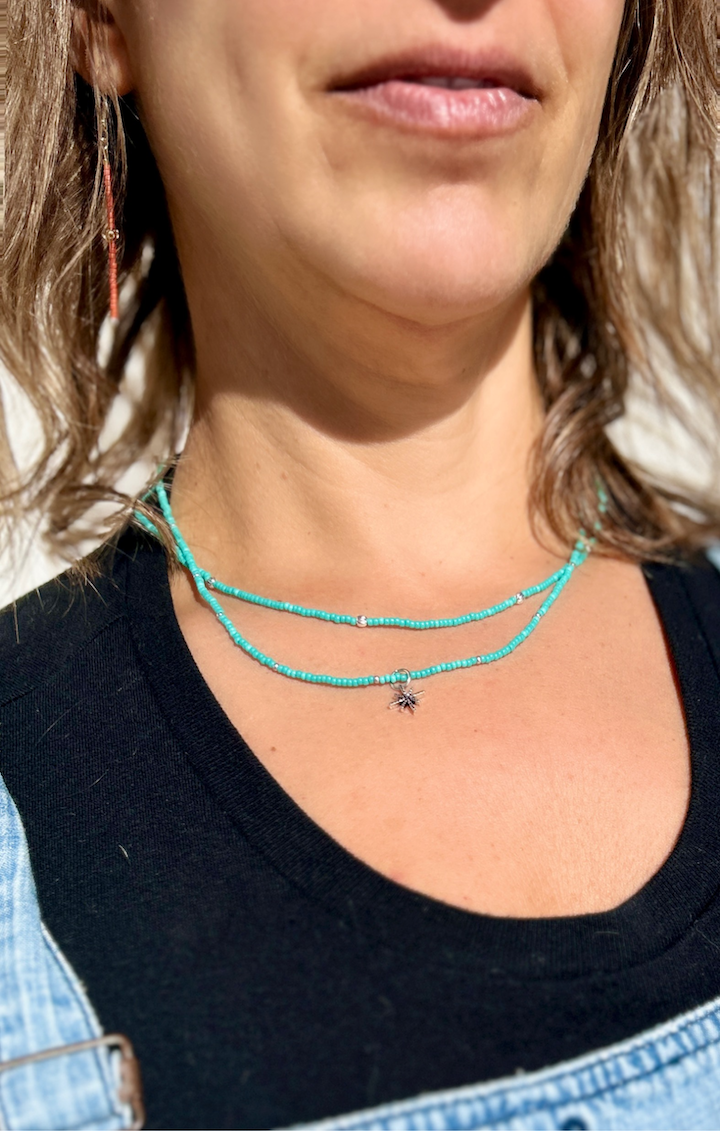 Gold Starburst Bling Turquoise Stretchy Seed Bead Necklace featuring turquoise Czech glass beads and a metallic gold starburst charm.