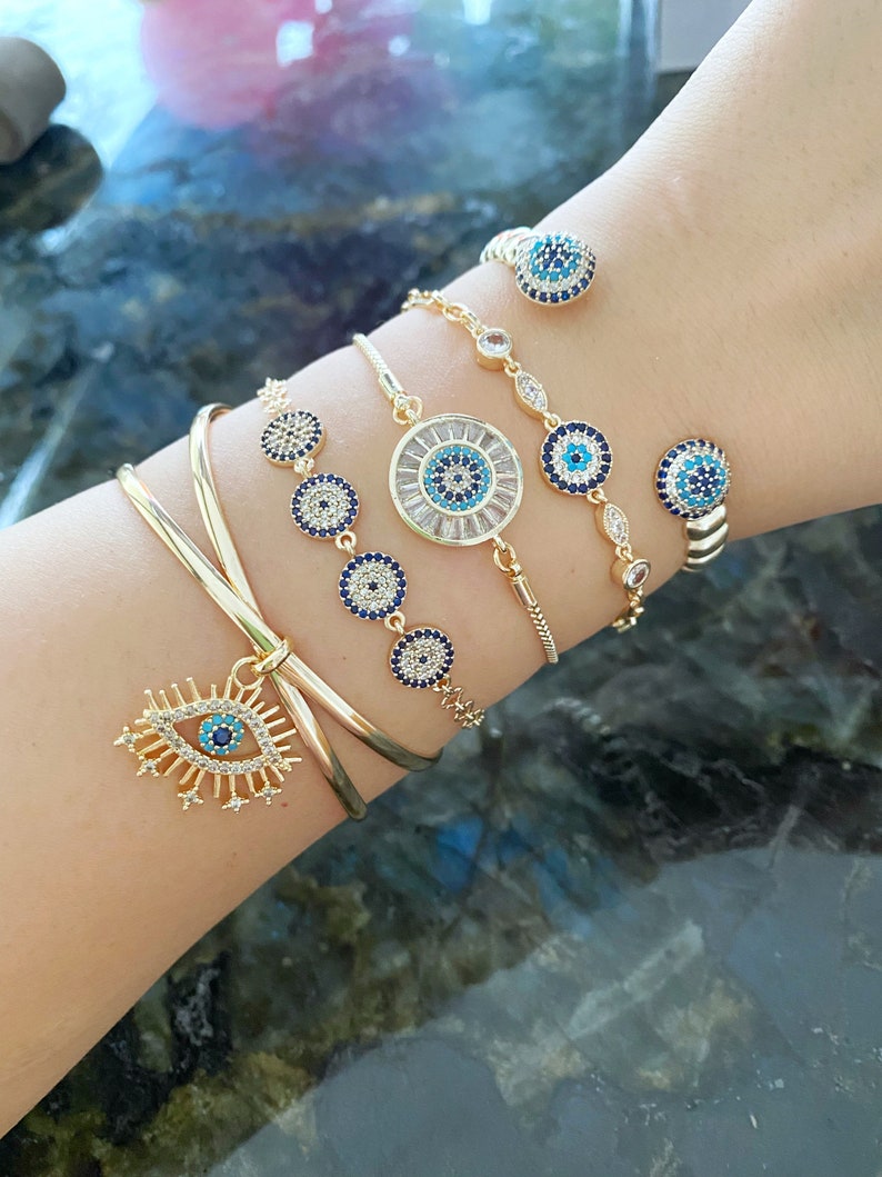 Gold Zircon Cuff Evil Eye Bracelet featuring a zircon charm on a tarnish-resistant stainless steel cuff.