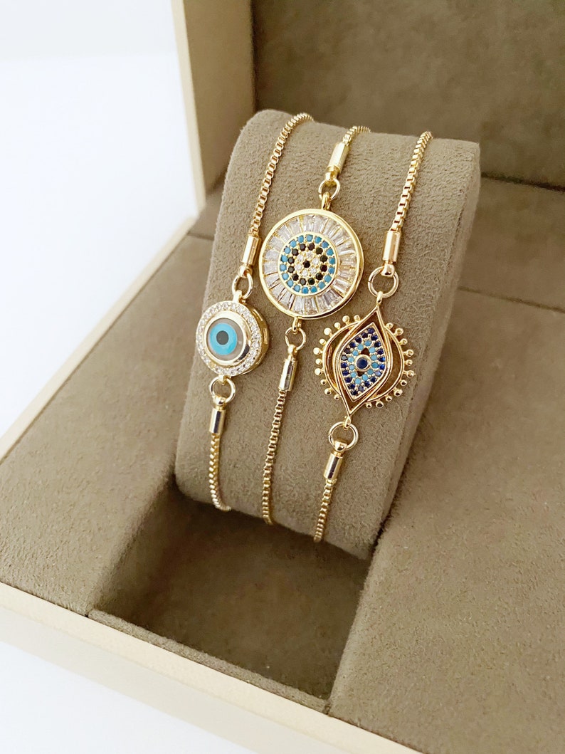 Gold Zircon Cuff Evil Eye Bracelet featuring a zircon charm on a tarnish-resistant stainless steel cuff.