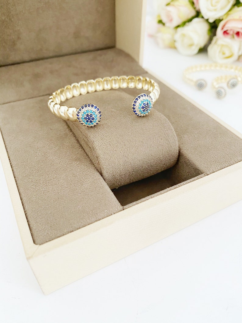 Gold Zircon Cuff Evil Eye Bracelet featuring a zircon charm on a tarnish-resistant stainless steel cuff.